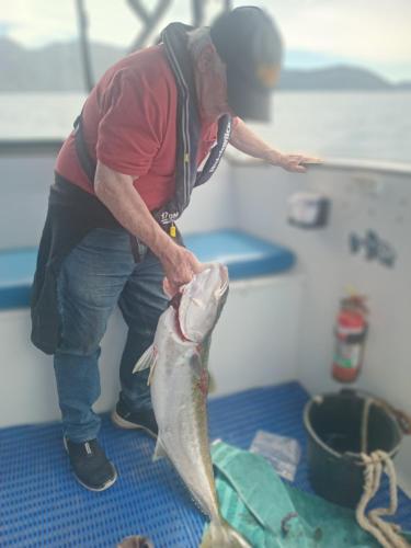 a man holding a fish in a boat at Bayheights in Picton