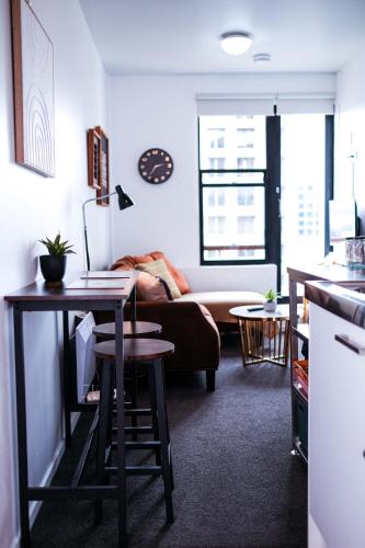 a living room with a couch and a table at Top Floor - Secure Parking - Great Location - Quiet - City Ciew in Wellington