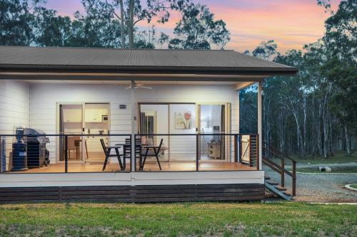 a house with a screened in porch with a deck at 27 Rows on Hermitage in Pokolbin