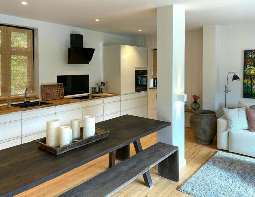 a kitchen and living room with a table and a couch at Stylish House Between Beach And Forest In Tisvilde in Tisvilde