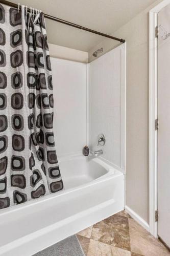 a bathroom with a bath tub with a shower curtain at Cozy Tiny Home Steps Away From Mt. Rainier in Ashford