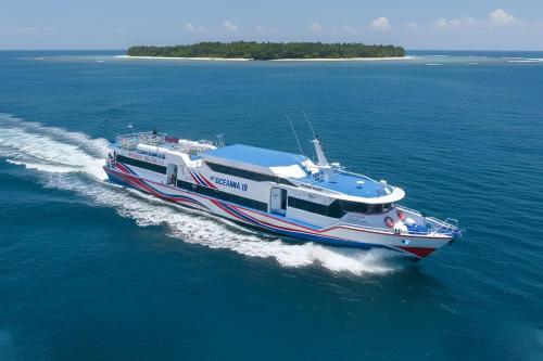 a boat in the water with an island in the background at Gilibooking tickets in Padangbai