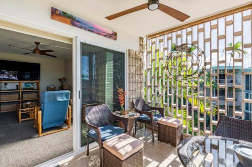 a porch with chairs and a table and a window at Alii Villas in Kailua-Kona