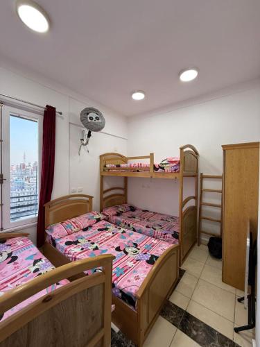 a room with three bunk beds and a window at Nabi Daniel Residence بيت البنات in Alexandria