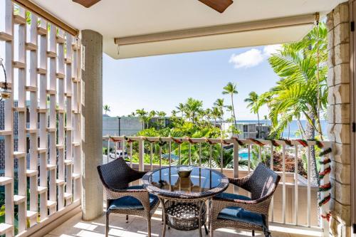 a patio with a table and chairs on a balcony at Alii Villas in Kailua-Kona