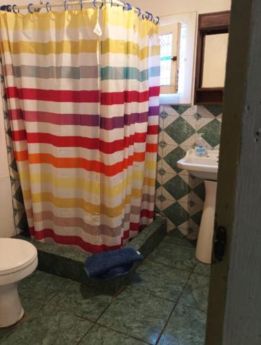 a bathroom with a shower curtain and a sink at Cabaña La Isla in Isla Negra