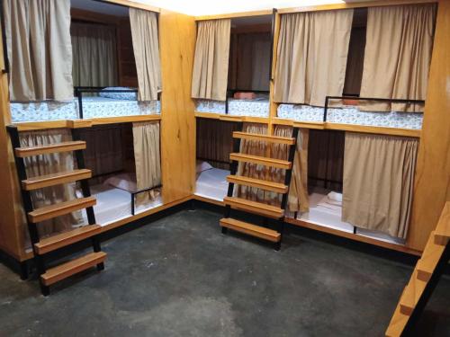 a room with four bunk beds with windows at Journeyy INN in General Luna
