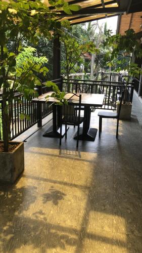 a patio with tables and chairs and a tree at Amanzi Residence in Kandy