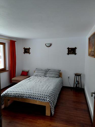 a bedroom with a bed and a chair in it at Cabana Țibleș Bichigiu in Bichigiu