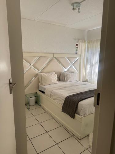 a bedroom with a large white bed with white pillows at House by balinty in Johannesburg