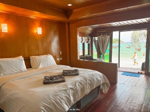 a bedroom with a bed with a robe on it at Lipe Power Beach Resort in Ko Lipe