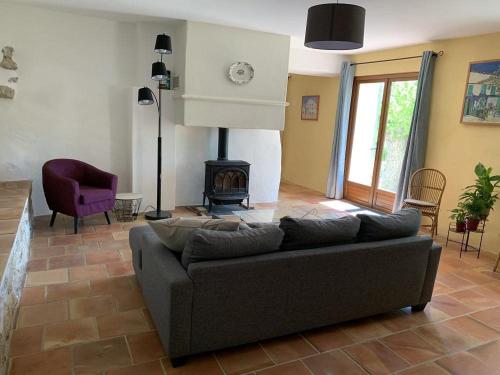 a living room with a couch and a fireplace at Mas de la clue - 2 personnes in Figanières
