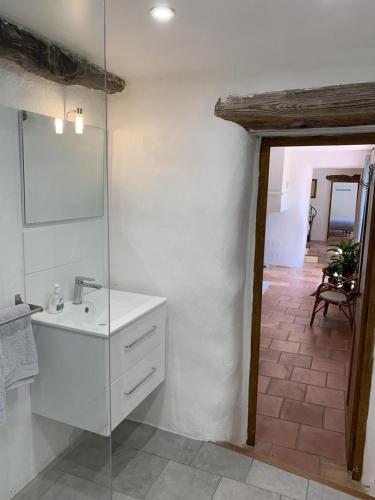 a white bathroom with a sink and a mirror at Mas de la clue - 2 personnes in Figanières