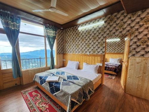 a bedroom with a bed and a large window at HILL MOUNT Cabin Home in Chamba