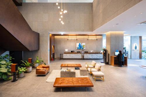 a lobby with couches and tables in a building at 부산 엘스테이 호텔 레지던스 EL STAY Busan Long Stay Hotel Residence l 아르떼20 OFF짚라인30 OFF스릴10 OFF 할인 in Busan