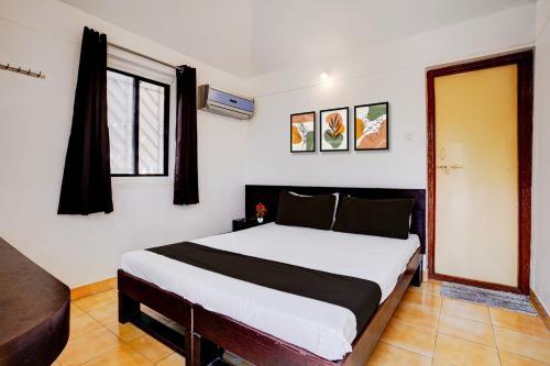 a bedroom with a bed and a window at Townhouse Amrapali Resort in Kolhapur