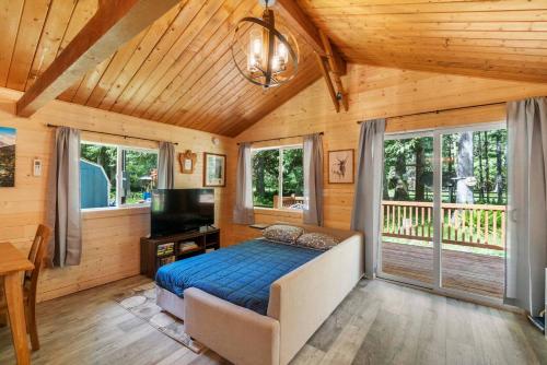 a bedroom with a bed and a flat screen tv at Cozy Cedar Cabin Steps Away From Mt. Rainier in Ashford