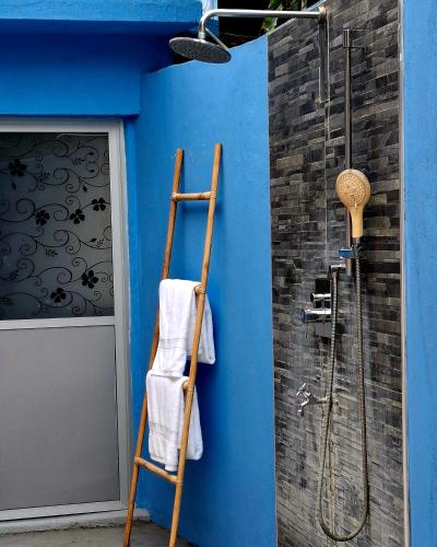 a bathroom with a blue wall with a ladder and a shower at Sansayin Homestay in Hambantota