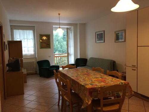 a kitchen and dining room with a table and chairs at Appartamento Piazza dei Monari in Cogolo