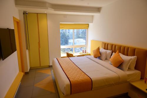 a bedroom with a large bed with a window at Lumis Hotel Whitefield in Bangalore