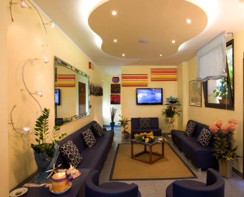 sala de estar con sofás azules y TV en Hotel Philadelphia, en Cattolica