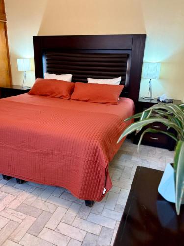 a bedroom with a large bed with red sheets and pillows at Casa completa, Excelente ubicación, Cerca IMSS in Torreón