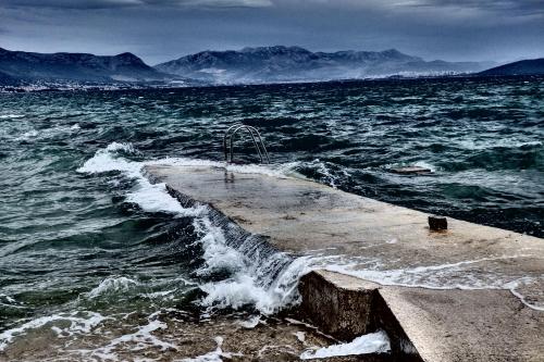 a pier in the middle of a body of water at Apartments & Bungalows Ivanović in Kaštela