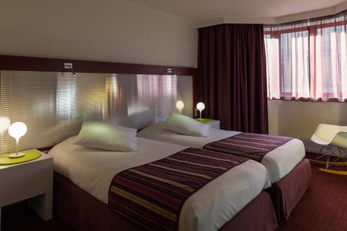 a hotel room with a large bed with two pillows at Mercure Strasbourg Centre in Strasbourg