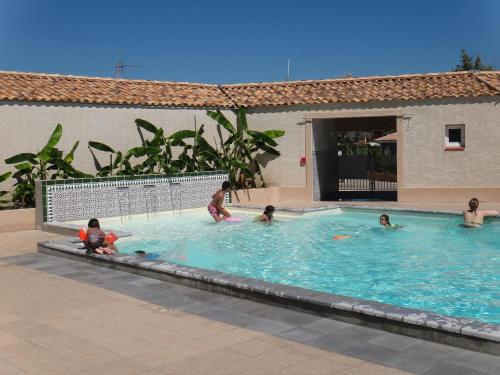 - un groupe de personnes se baignant dans une piscine dans l'établissement Camping Hameau Des Cannisses, à Gruissan