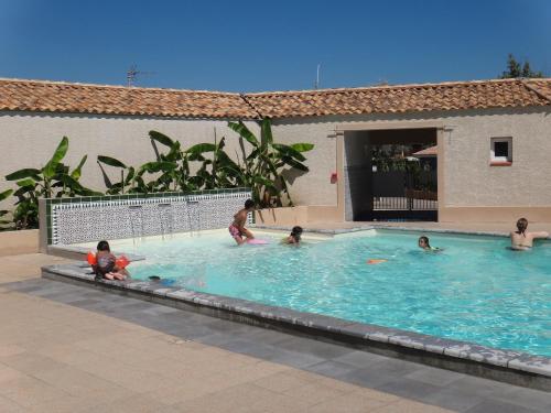 un grupo de personas nadando en una piscina en Camping Hameau Des Cannisses, en Gruissan