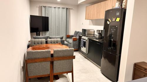 a living room with a black refrigerator and a kitchen at Moderno Loft Primer Cuadro Centro Historico Guadalajara in Guadalajara