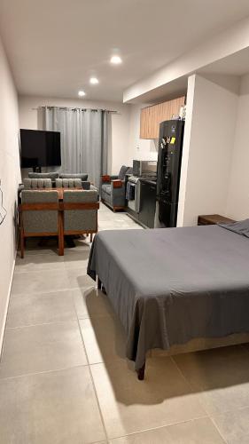 a room with a bed and a tv and a kitchen at Moderno Loft Primer Cuadro Centro Historico Guadalajara in Guadalajara
