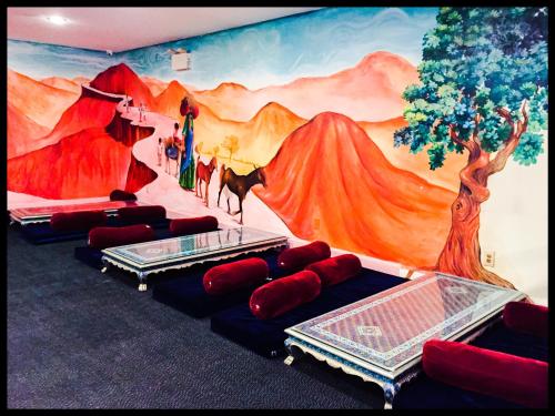 a room with a mural on the wall with red pillows at Days Inn by Wyndham Tannersville in Tannersville