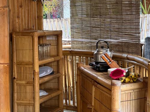 a wooden shelf with a tea kettle on a balcony at Bambuu in Gili Islands