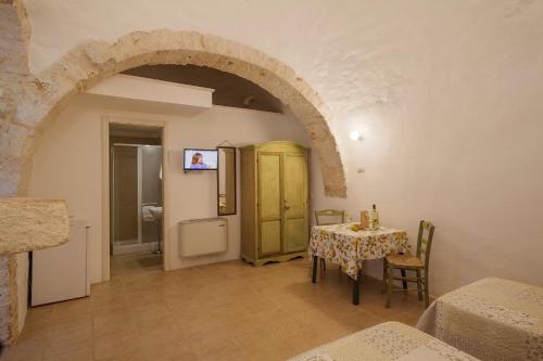 a dining room with a table and a yellow cabinet at Masseria Ferri in Ostuni