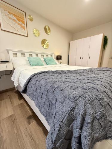 a bedroom with a large bed with a gray blanket at Apartment in the heart of Mexico City's historic in Mexico City
