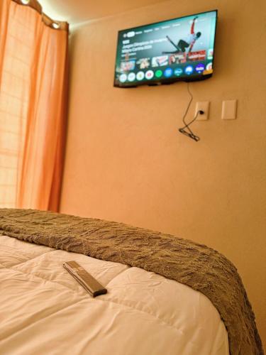 a bedroom with a bed with a tv on the wall at Apartment in the heart of Mexico City's historic in Mexico City