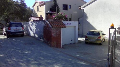 a car parked in a parking lot next to a garage at Apartments Malina in Tučepi