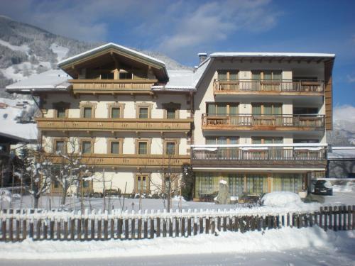 a large building with a fence in the snow at Hotel Garni Elisabeth in Zell am Ziller