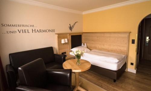 a hotel room with a bed and a table and chairs at Alpenstadthotels in Bad Reichenhall