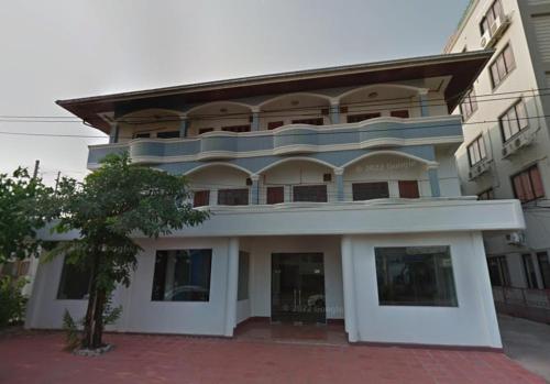 un grand immeuble blanc avec un grand balcon dans l'établissement Harmony Hotel, à Vientiane