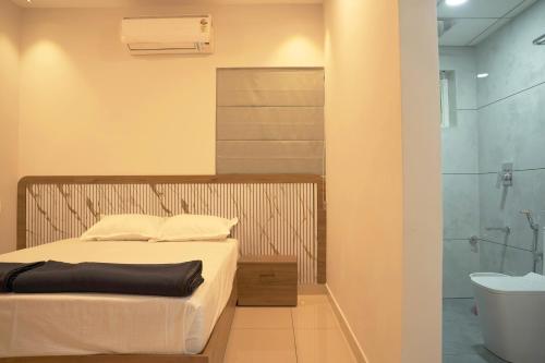 a bedroom with a bed and a bathroom with a shower at Blue Vista Residency in Kalpetta