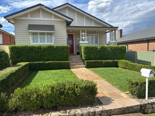 a house with green hedges in front of it at Alvane Cottage in Goulburn