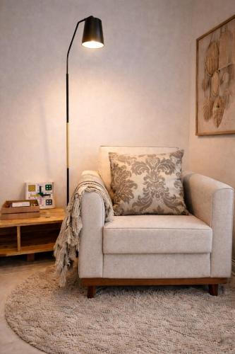a living room with a couch and a lamp at Studio 929 Gold Star 400m Ferry to Rio 1Gb Wi-Fi in Niterói