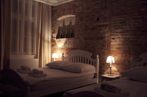 a bedroom with a white bed and a brick wall at Dwie Wieże in Międzyzdroje
