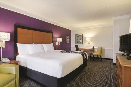 a hotel room with a large bed and a desk at Baymont by Wyndham Greenville Woodruff Rd in Greenville