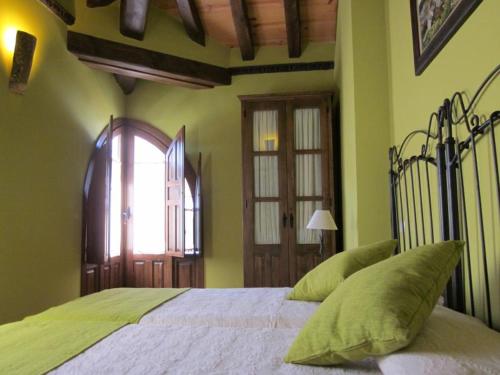 a bedroom with a large bed with green walls at Casa Rural Las Albertas in Arbancón