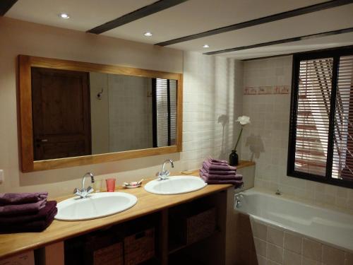 une salle de bain avec deux lavabos, un miroir et une baignoire dans l'établissement La Maison de l'Isle, à LʼIsle-sur-la-Sorgue