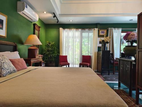 a bedroom with a large bed and green walls at Phu View Hideaway in Ban Kham Proi