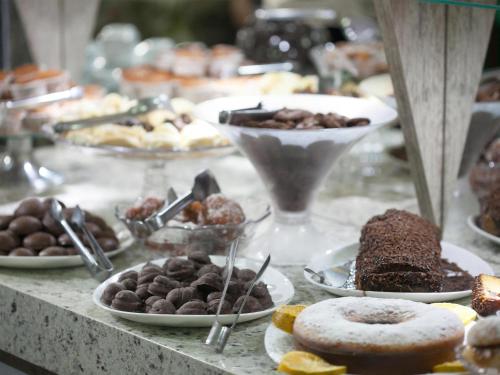 een tafel vol verschillende soorten gebak en desserts bij Ody Park Resort Hotel in Iguaraçu